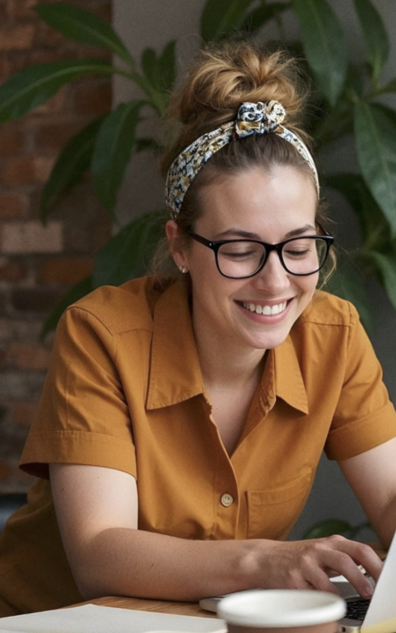 Collega die glimlacht en aan het werk is op haar laptop