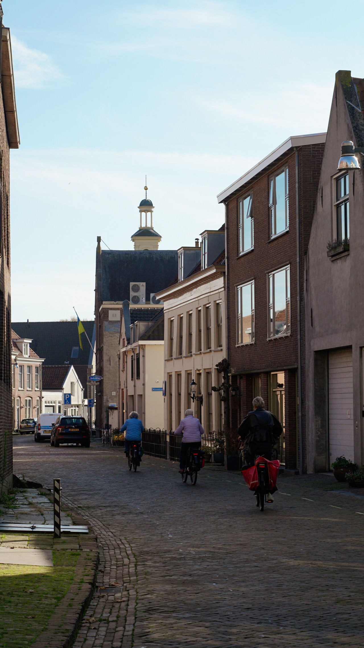 Drie mensen op de fiets in een Nederlandse straat