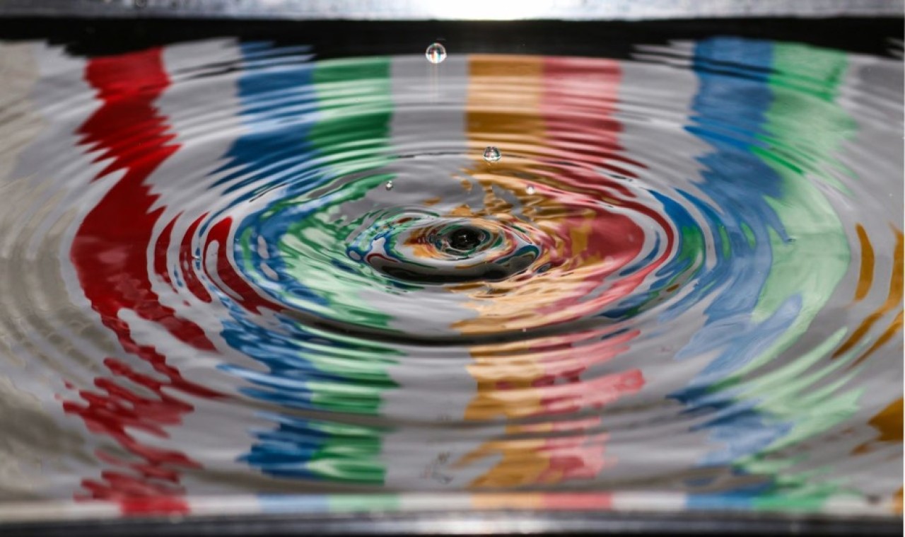 Een druppel water die valt in water en kringen op het water veroorzaakt.