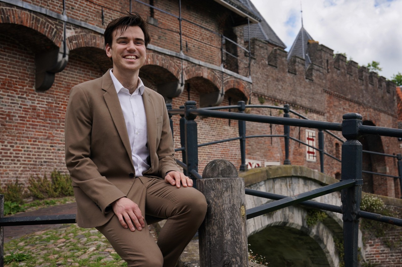 Joris Bol poseert voor zijn portretfoto bij het hek bij de Amersfoortse Koppelpoort