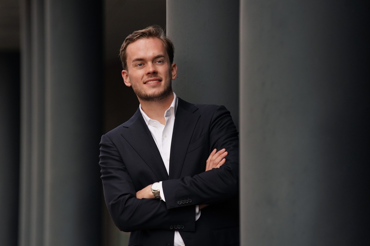 Luuk Verheggen poseert naast een aantal pilaren voor zijn portretfoto