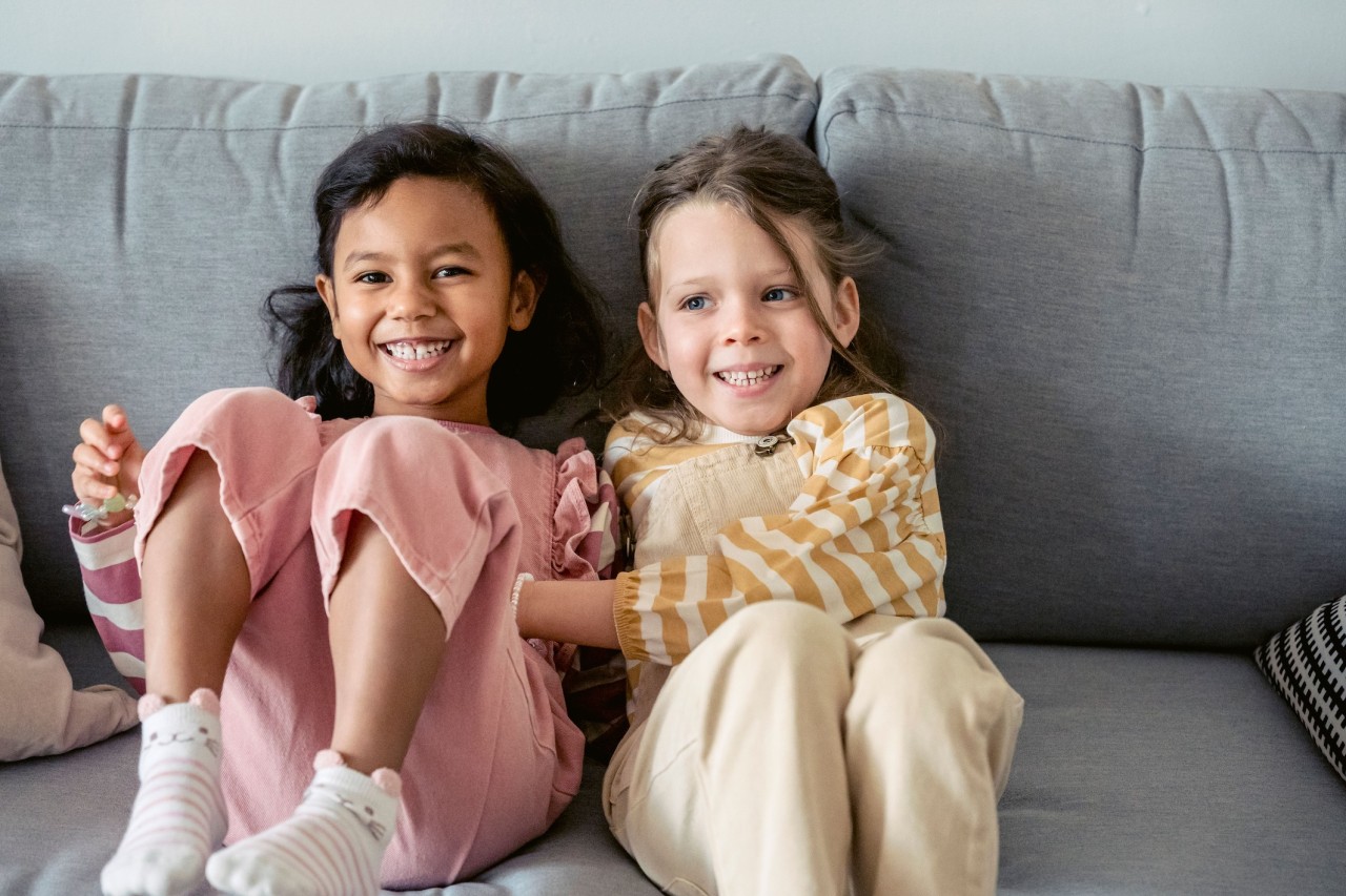 Twee meisjes op de bank die samen lachen
