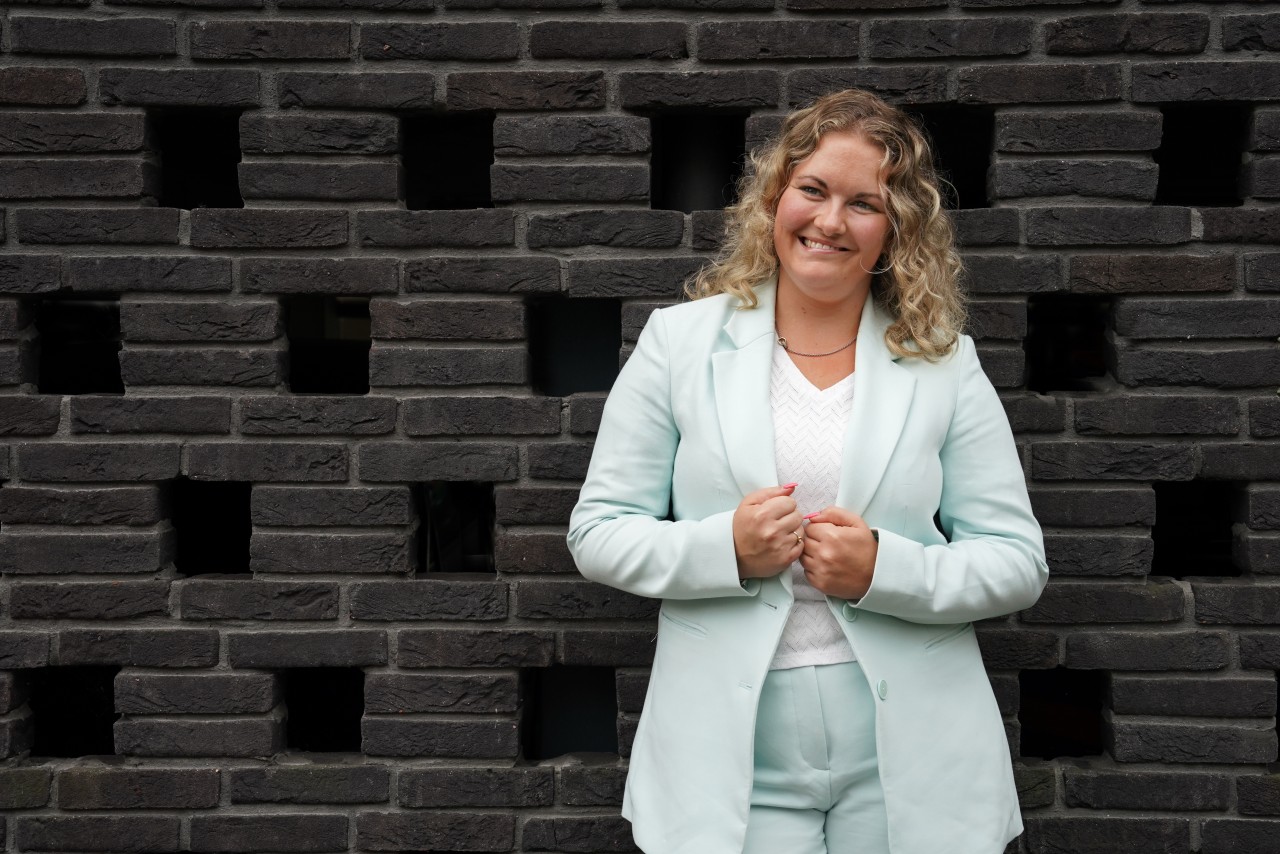 Donna Kooij poseert tegen een donkere muur