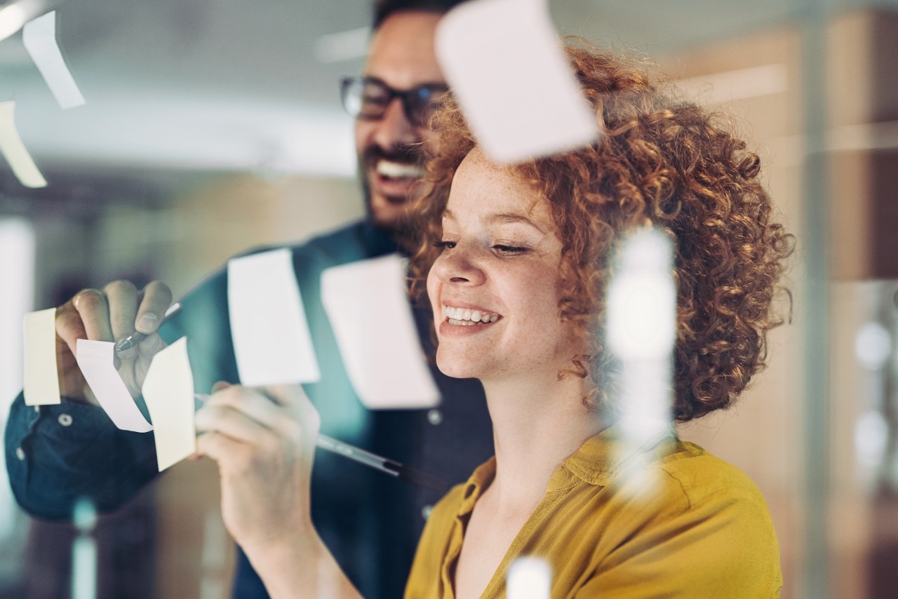 Twee mensen werken samen bij een post-it wand